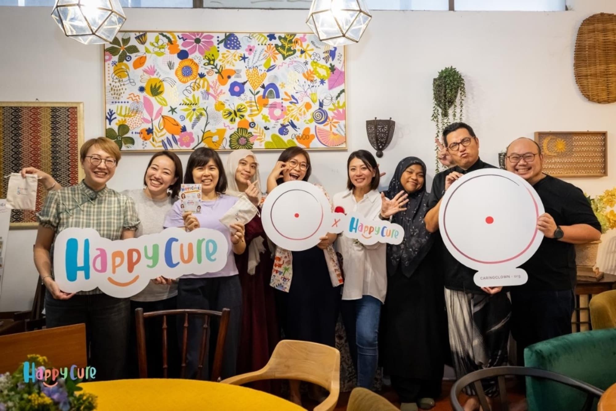 Happy Cure volunteers holding Happy Cure signs at a gathering