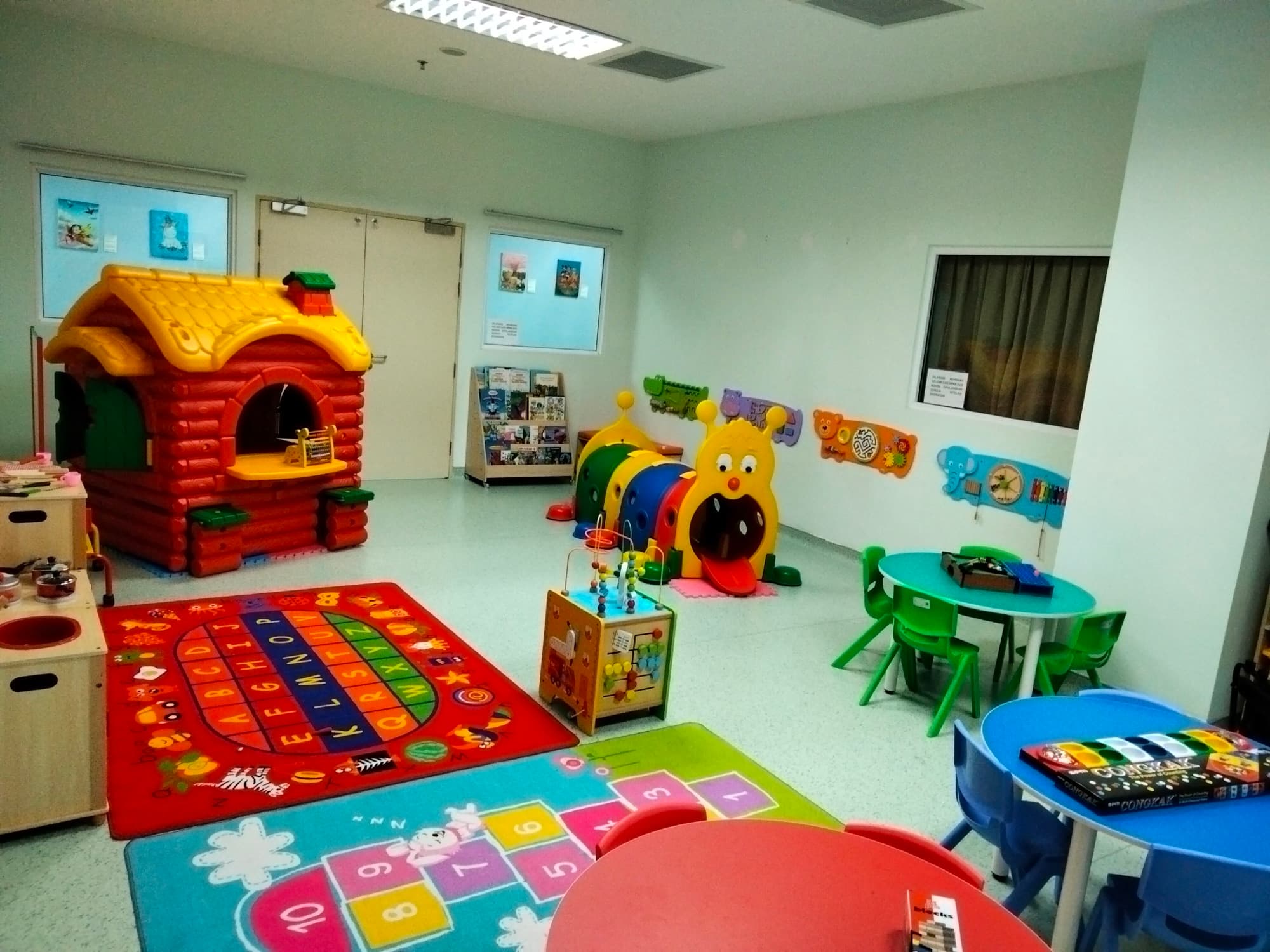 Oncology ward playroom with a play house and colourful mats